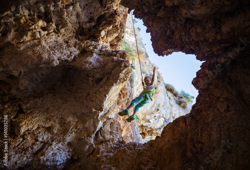 Little boy being lowered down while top rope climbing