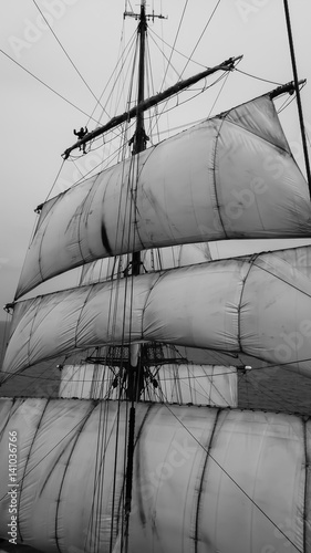 tallship sailor aloft at sea on a traditional squarerigger photo