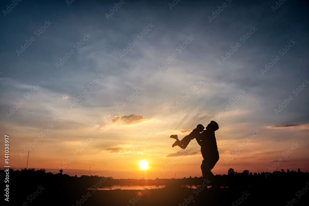 Fototapeta premium Family concept, Silhouette of father throwing son into the sky. , father and son at lake with sunset background