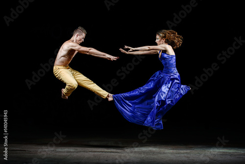 Dancing couple in the darkness, bounce in the dance movement.