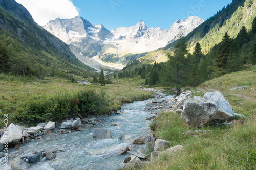 Gebirgsfluß in den Alpen mit Gletscher im Hintergrund