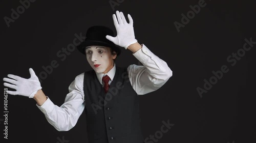 The mime is behind an invisible wall. Black background