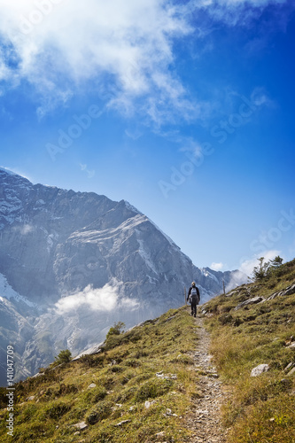 Hiker on mountain hiking trail in swiss alps