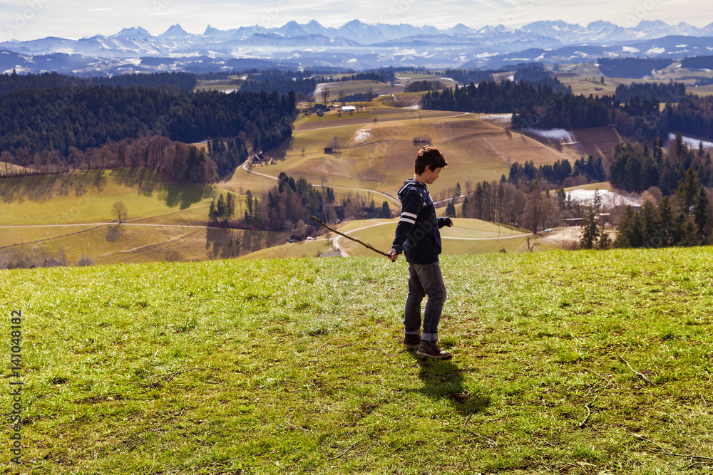 Boy throws stick, mountain landscape, the concept of anger
