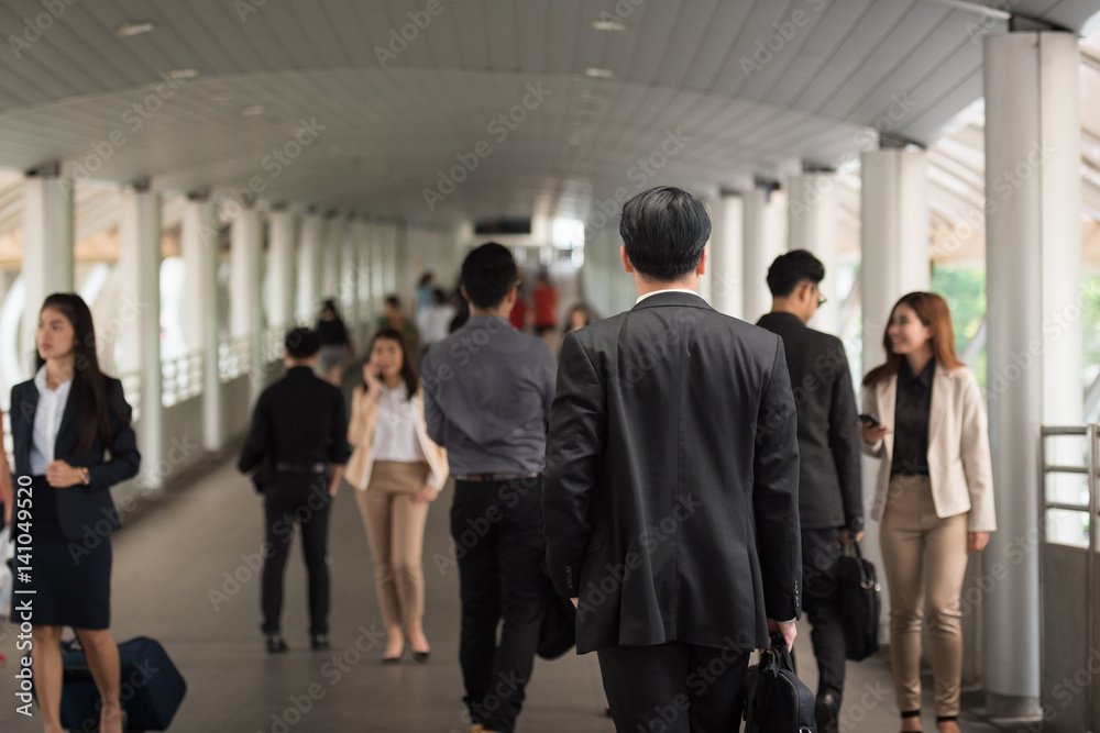 Smiling businessman standing upright in time working day