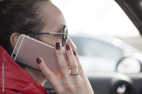 женская рука с телефоном за рулем автомобиля