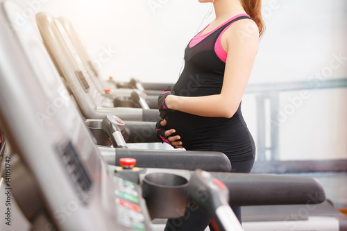 Pregnant woman exercising in the gym photo