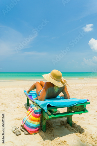 Fototapeta Naklejka Na Ścianę i Meble -  Woman sitting on a chair at the beach