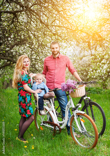 Young family on a bicycles in the spring garden