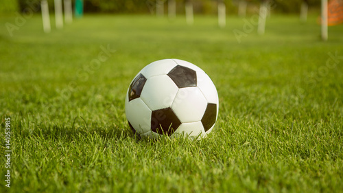 soccer ball lie in lawn field in summer day before friendly match