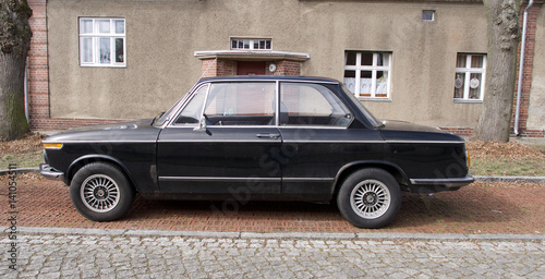 Old black vintage car parked in front of a house © Christoph Kaufmann