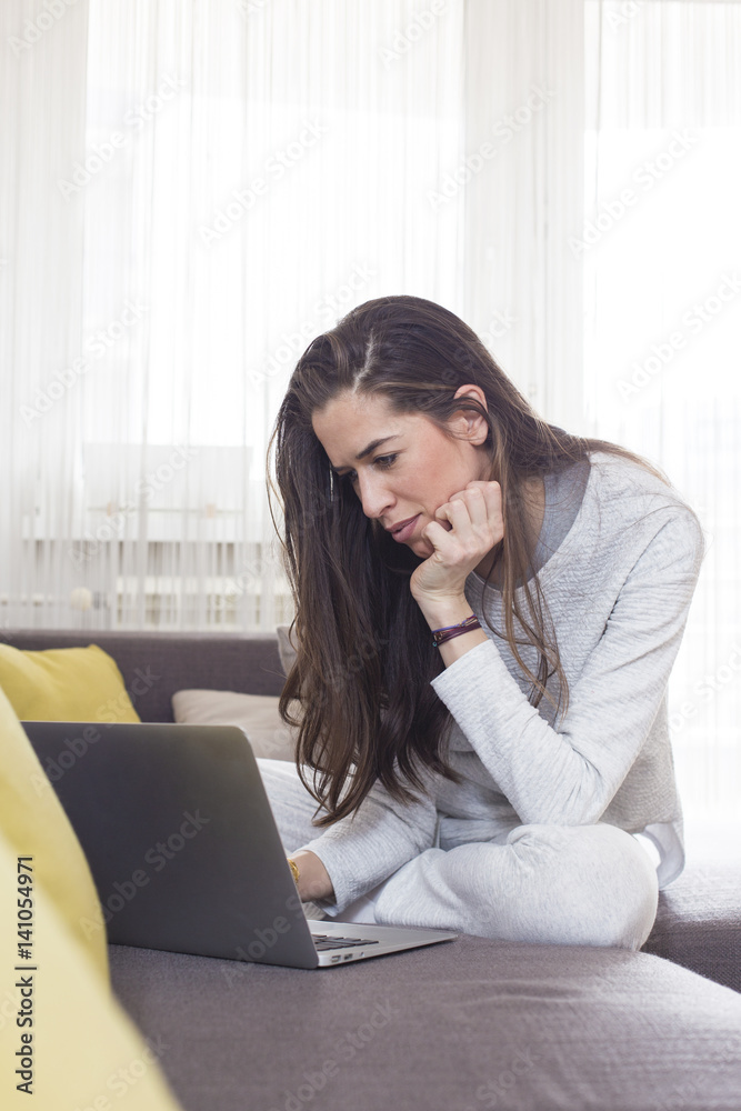 Young woman working on laptop at home. Morning scene Young woman working on laptop at home. Morning scene