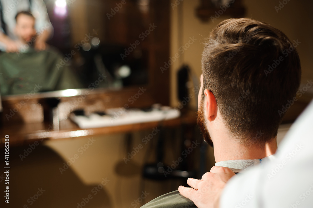 Fototapeta premium Master cuts hair and beard of men in the barbershop