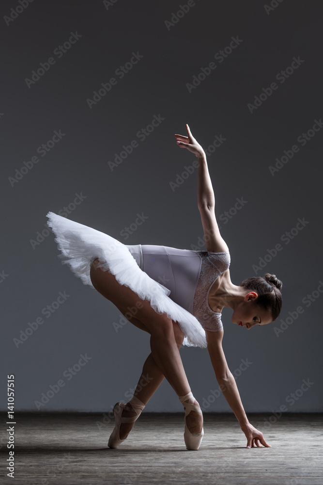 Fototapeta premium Young beautiful ballerina posing in studio