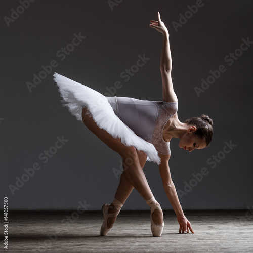 Young beautiful ballerina posing in studio