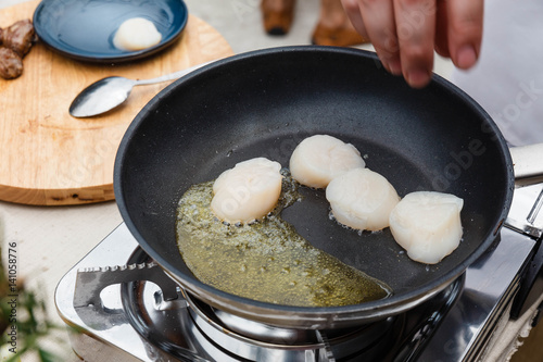 Chef Fried Scallops with Rosemary Oil in Pan with Spoon.