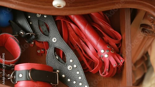 Mans hand takes sex toys from the bedside table