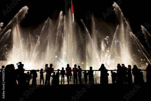 Silhouettes of people watching the musical fountain show