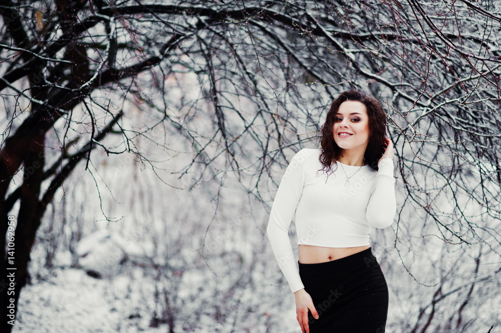 Curly brunette girl background falling snow, wear on black mini skirt and wool stockings. Model on winter. Fashion portrait at snowy weather. Instagram toned photo. Curly brunette girl background falling snow, wear on black mini skirt and wool stockings. Model on winter. Fashion portrait at snowy weather. Instagram toned photo.