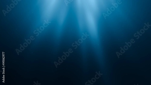 Sunlight rays shining through ocean surface. View from underwater. 3D rendered seamless loop animation.
