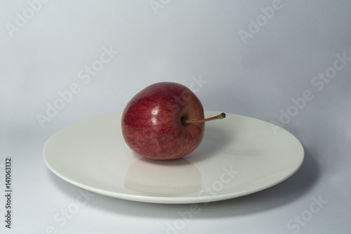 Manzana de lado en plato blanco photo