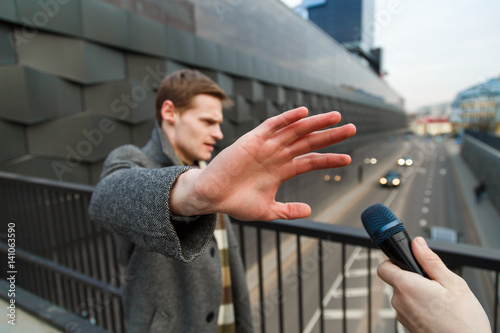 Foto A young man is categorically against giving an interview to a journalist on the street