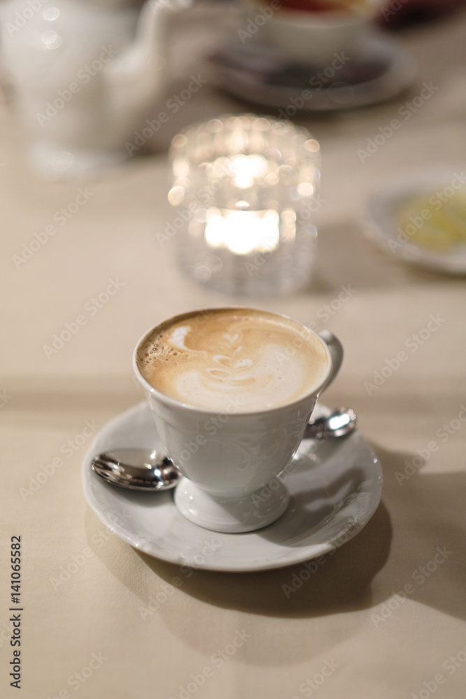 A cup of cappuccino coffee on a dessert table. A cup of cappuccino coffee on a dessert table.