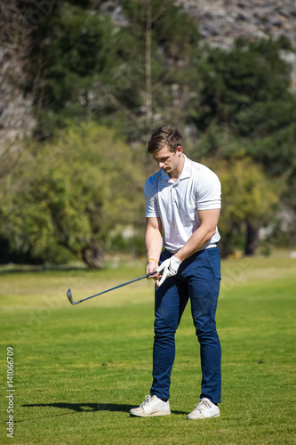 Young golfer getting ready on a golf course to play a round of golf