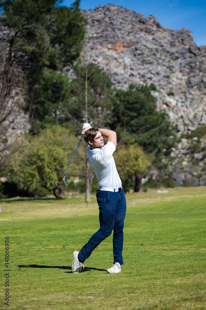 Young golfer getting ready on a golf course to play a round of golf Young golfer getting ready on a golf course to play a round of golf
