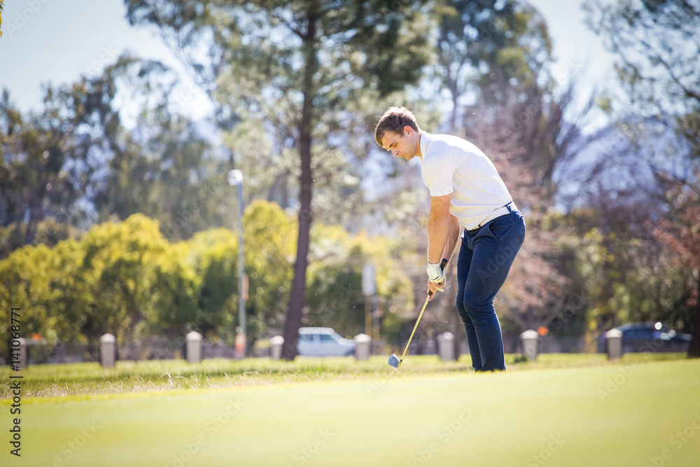 Close up view of a golfer playing a chip shot on a golf course in south africa with back light. Close up view of a golfer playing a chip shot on a golf course in south africa with back light.