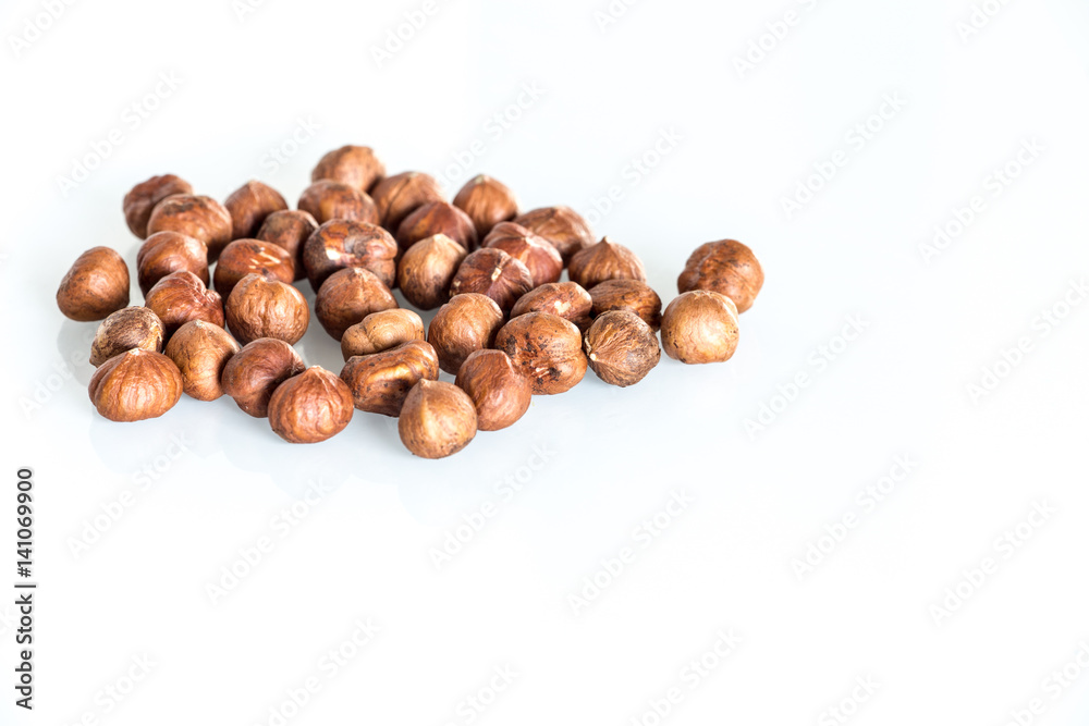Delicacies hazelnuts scattered on the white background. Delicacies hazelnuts scattered on the white background.