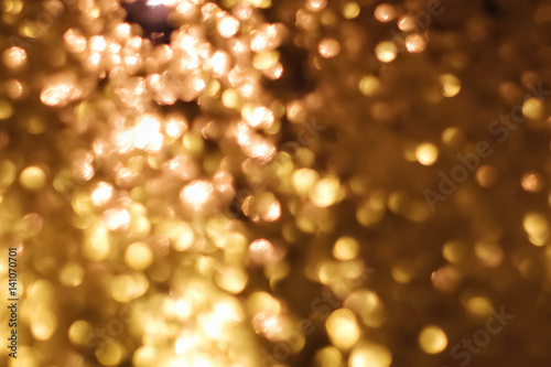 Golden abstract sparkles or glitter lights. Festive gold background.defocused circles bokeh or particles. Valentines day template photo