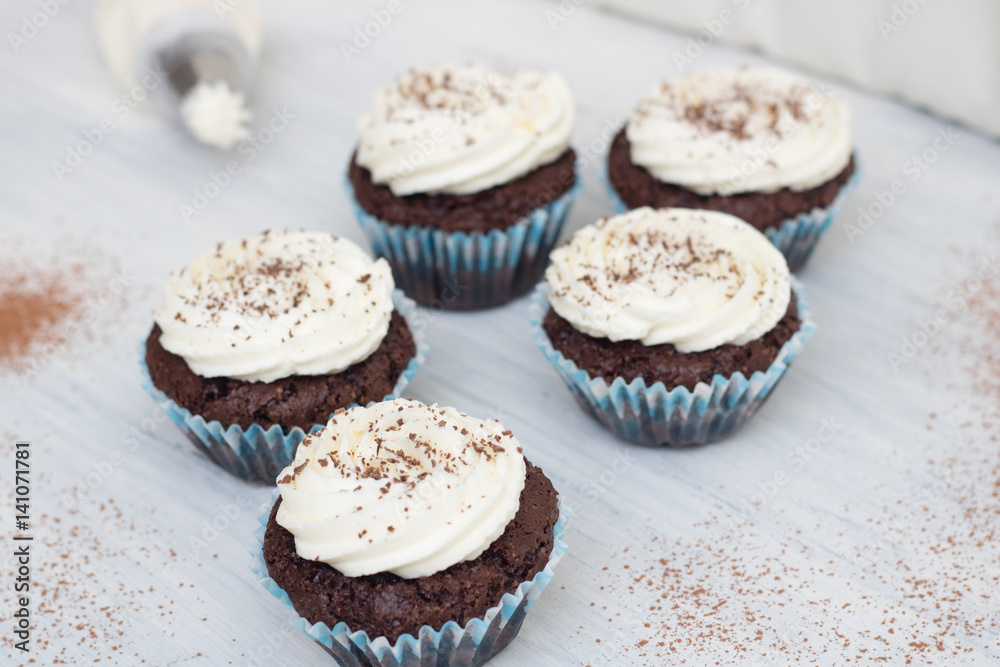 Chocolate cupcakes on white wood background, copy space