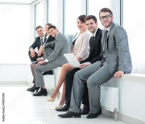 business team sitting on the windowsill in the new office © ASDF