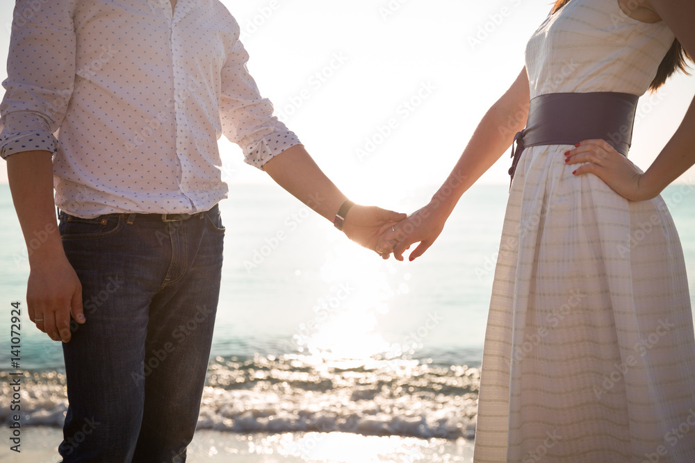 Man and woman holding hands on ocean sunset. Love, marriage and happiness. Man and woman holding hands on ocean sunset. Love, marriage and happiness.