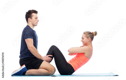 happy sportive man and woman doing sit-ups