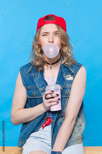 young pretty teenager girl emotional posing on blue background, fashion lifestyle people concept. April Fools' Day photo