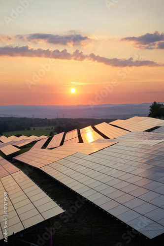 Obraz na płótnie Sunset over solar power plant in countryside. View from above. w salonie