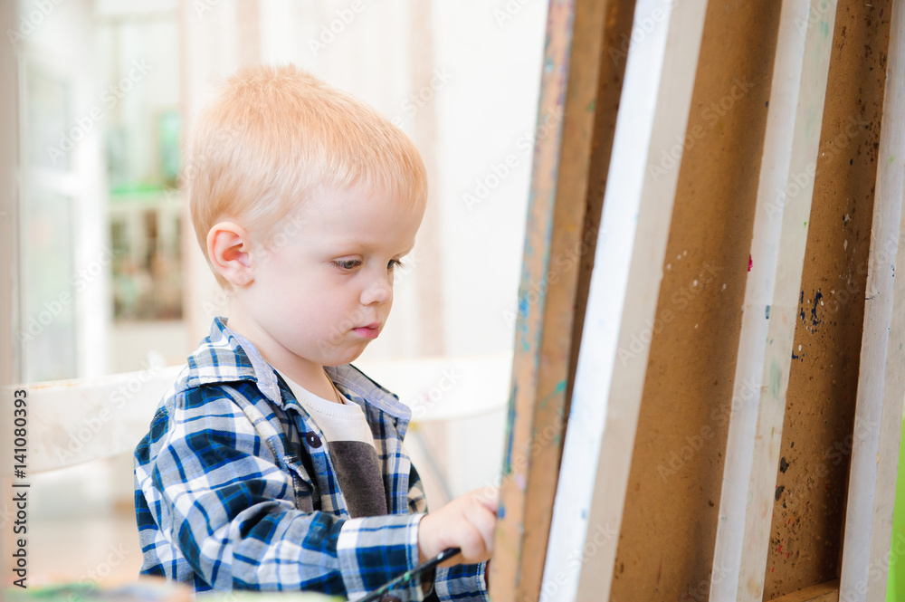 a child draws a picture paints on art lesson