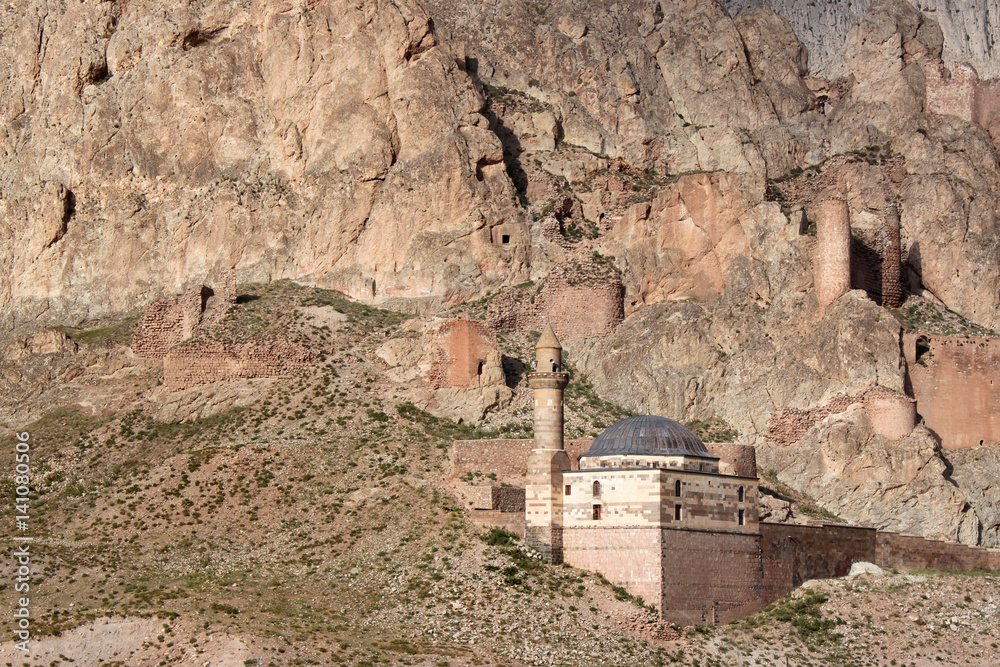 eine kleine Moschee namens Eski Bayezıt Cami mit Minarett klebt unterhalb einer Burgruine an einer Felswand bei Dogubeyazit, Provinz Agri, Kurdistan, Anatolien, Türkei