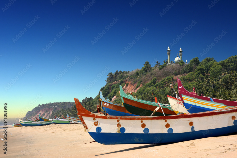 Fototapeta premium colourful fishermen boats in fron of Varkala South Cliff with mosque on top, Kerala, India