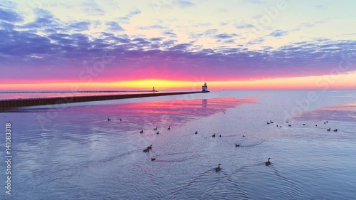 Amazing Lake Michigan scenic pre-dawn glow with Lighthouse, Geese, aerial flyover.
 photo