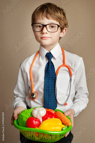 A young boy with acne skin in white coat Holds a basket of vegetables photo