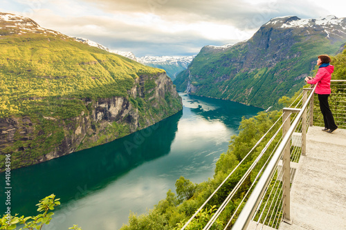 Tourist looking at Geirangerfjord from Flydasjuvet viewpoint Norway photo