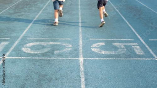 Slow motion Young Asian boy start to running on blue track in the stadium in day time.
