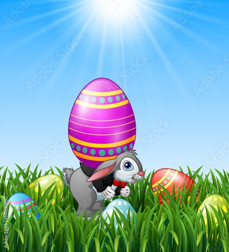 Cartoon easter bunny carrying easter eggs in the grass background 
