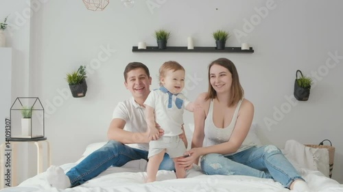 Portrait of the happy family with little child looking at camera photo