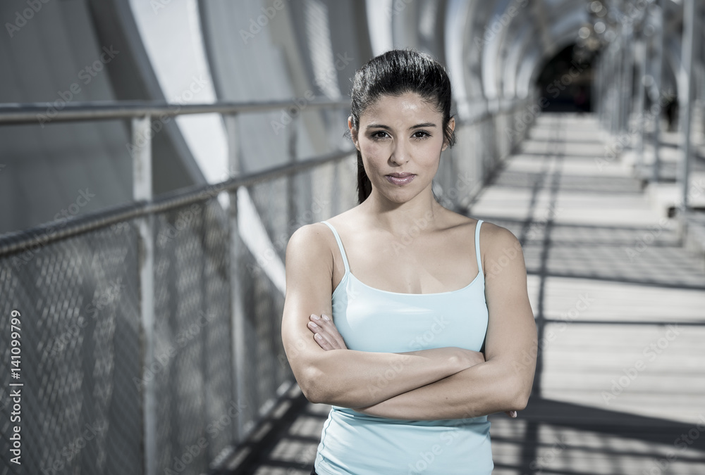 attractive hispanic brunette woman looking cool and defiant after running workout