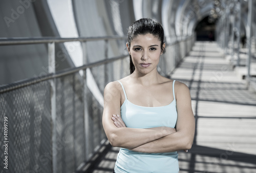 Obraz na plátně attractive hispanic brunette woman looking cool and defiant after running workou