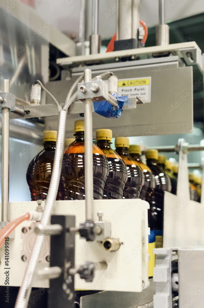 Plastic bottles with beer on the conveyor of an automatic packing machine.